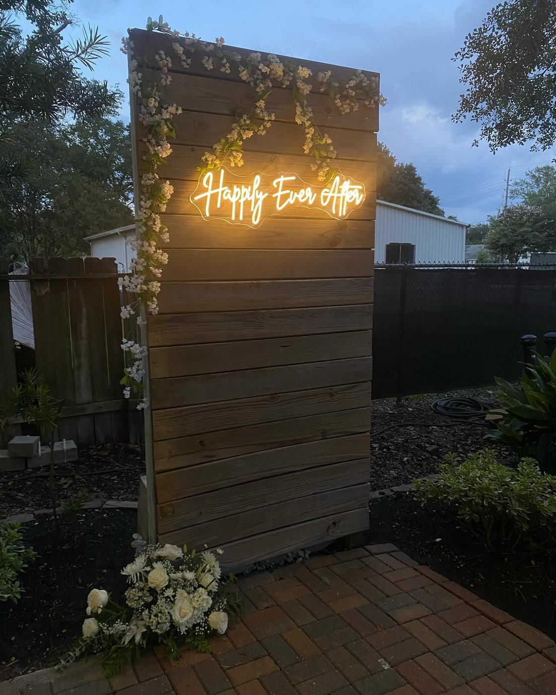 White floral arch and draped table at an outdoor wedding